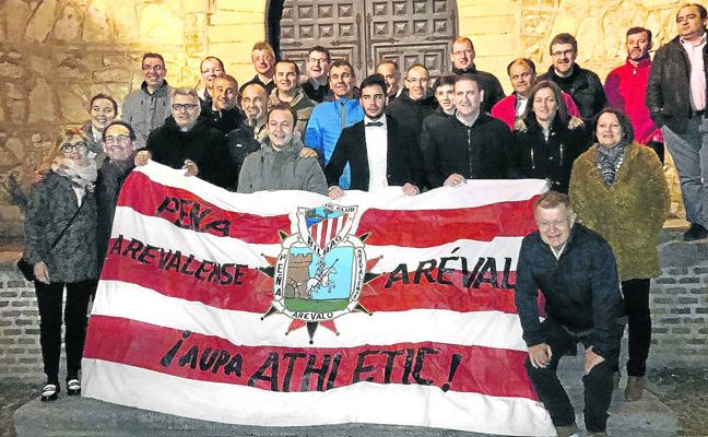 Los socios de la agrupación posan en una calle de Arévalo con una bandera rojiblanca con su logotipo./