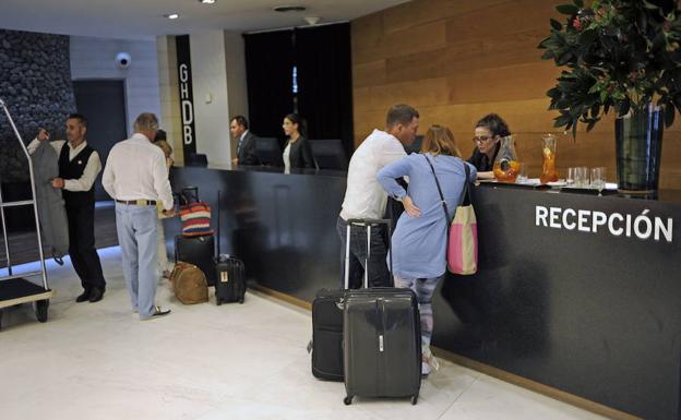 Turistas hacen el registro de entrada en un hotel.