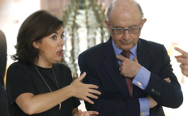 La vicepresidenta del Gobierno, Soraya Sáenz de Santamaría, conversa con el ministro de Hacienda, Cristóbal Montoro, durante un acto la semana pasada.