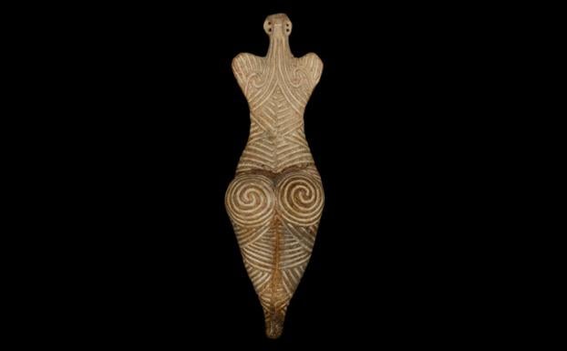 Vista de una figura neolítica de una mujer de espaldas.