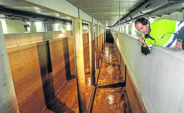 Un operario supervisa la limpieza del fondo del tanque de tormentas de Etxebarri con la salida en tromba de 50 metros cúbicos de agua./Borja Agudo