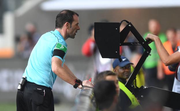 El árbitro Marco Fritz usando el VAR en un partido de la liga alemana./Afp