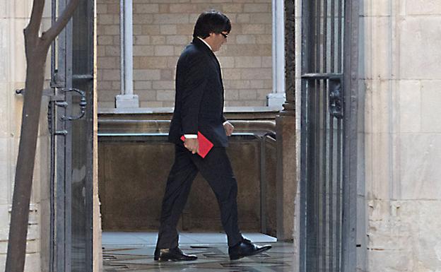 Puigdemont se dirige hacia su despacho en el Palau de la Generalitat, el pasado martes./EFE