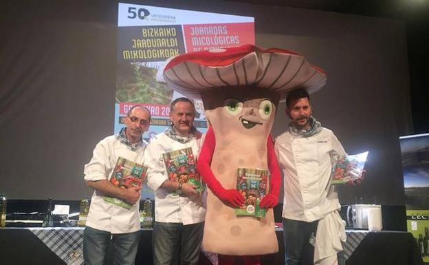 Cocineros y la mascota de las jornadas sostienen el álbum. / E.C.