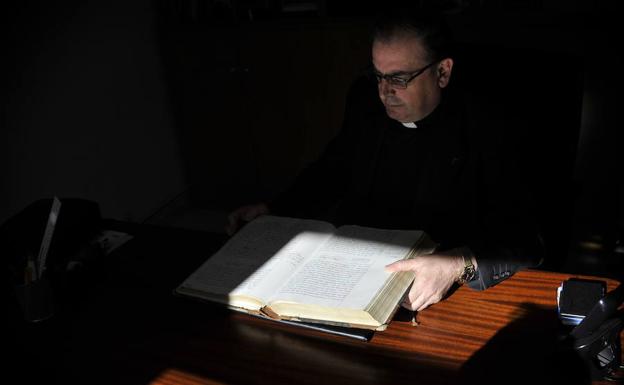Victor Santos sostiene el libro parroquial que recoge los nombres de los soldados vascos republicanos enterrado en una fosa del cementerio de Limpias./IGNACIO PÉREZ