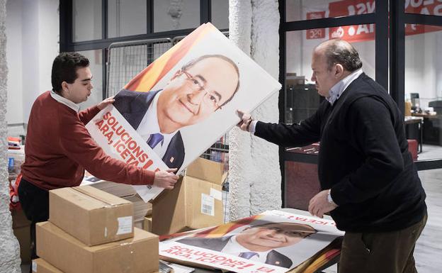Marc Guallar y Luis Fuente colocan propaganda electoral en la sede del PSC en el barrio barcelonés del Eixample. /Vicens Giménez