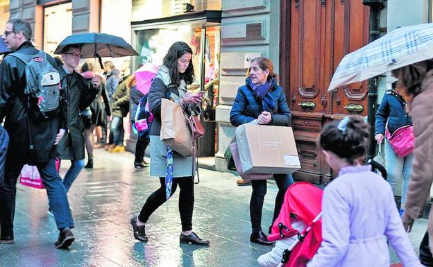 Clientas cargadas de bolsas con compras navideñas, una escena habitual estos días en las calles del centro./BORJA AGUDO