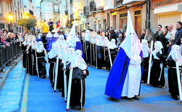 El cuerpo de nazarenos alumbra el camino al paso a la procesión de la Cena del Señor, que recorre las calles de Haro la noche del Jueves Santo./ R. SOLANO