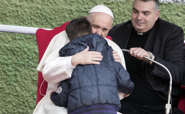 El Papa abraza al niño durante el acto en Corviale. /AGENCIAS