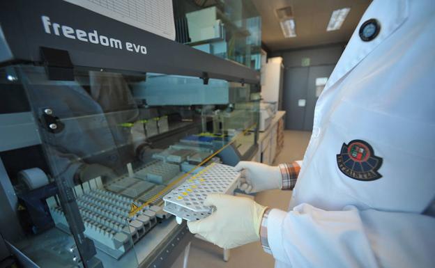 Un agente del laboratorio de la Policía Científica sostiene varias muestras de ADN en la central de la Ertzaintza en Erandio./BORJA AGUDO