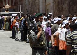 Un policía israelí vigila mientras palestinos participan en una oración del Ramadán. / Efe/