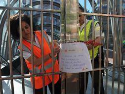 Dos trabajadores colocan un cartel en una estación para avisar de la avería./ Fernando Gómez/