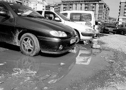Imagen del parking provisional de Romo, lleno de baches y charcos. / PEDRO URRESTI/
