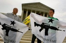 Dos activistas a favor de las armas muestran su satisfacción ante la sede del Supremo. / AFP/
