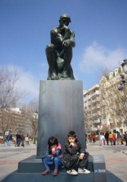 Dos niños posan con 'El Pensador' de Rodin en un céntrico parque de Granada. / EL CORREO/