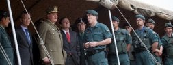 El Rey de España, flanqueado por autoridades y mandos, observa el campo de prácticas al tiempo que atiende las explicaciones del teniente coronel Félix Jesús Blázquez, jefe del Grupo de Acción Rápida. / MIGUEL HERREROS/