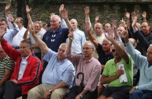 Los cofrades alzan la mano para aprobar un asunto durante la junta. / JOSÉ MONTES/