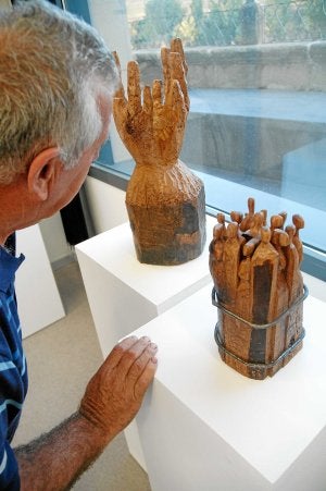 Un visitante observa dos de las piezas realizadas con los leños del olmo frente al Ebro. ::
R. SOLANO/