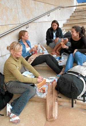 Unas turistas comen unos bocatas junto al Guggenheim./ L. A. GÓMEZ/
