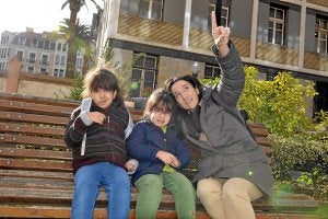 Naiara, con sus dos niñas, Araitz, de siete años, e Ixone, de cinco, sentadas frente al colegio público Cervantes de Bilbao, en el que están escolarizadas. /Maite Bartolomé/
