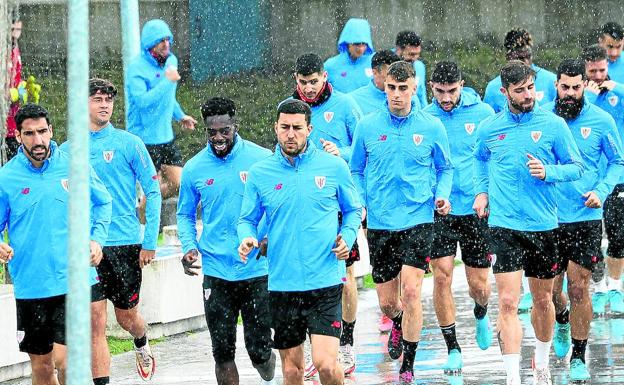 Los jugadores del Athletic se dirigen a entrenar bajo la lluvia de ayer jueves. /pankra nieto