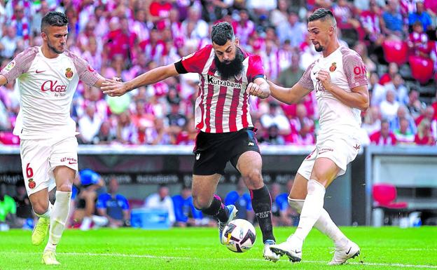 Asier Villalibre trata de zafarse de dos jugadores del Mallorca. 