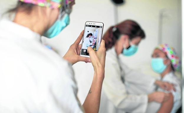 A health worker immortalizes the moment in which a colleague receives the vaccine. 