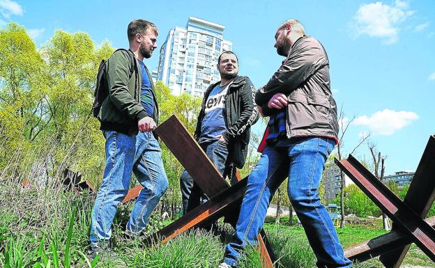 Nikita, the first from the right, with his friends who welcome him in kyiv, where trenches continue to be opened and anti-tank obstacles placed. 