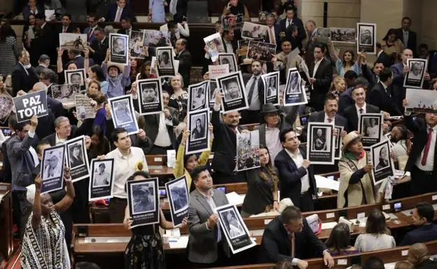 Left-wing deputies show Iván Duque portraits of social leaders killed by violence in Colombia. 
