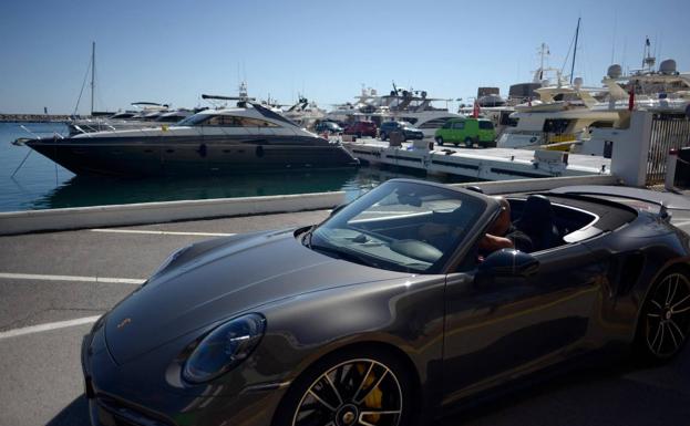 A man drives a high-end vehicle in Puerto Banús, the most luxurious area in Marbella. 